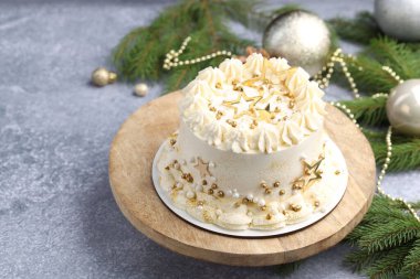 Gri masadaki Noel dekorlu lezzetli pasta, yakın plan.