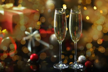 Bardakta köpüklü şarap, şenlikli dekor, ışık. Yeni yıl tebrik kartı.