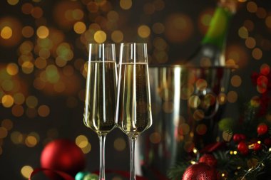 Bardakta köpüklü şarap, şenlikli dekor, ışık. Yeni yıl tebrik kartı.