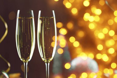 Bardakta köpüklü şarap, ışık. Yeni yıl tebrik kartı.