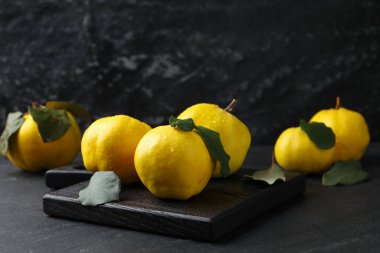 Siyah masada yeşil yapraklı olgun ayva balıkları, yakın plan.