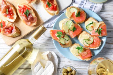 Somon, salatalık, limon, prosciutto ve beyaz ahşap masada şarap ile nefis bruschetalar.