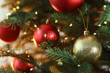 Güzel mücevherler ve şenlikli ışıklar köknar ağacının dallarında bulanık arka planda asılı, yakın plan. Noel tebrik kartı.