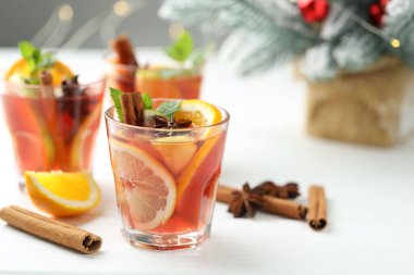 Bardaklarda, baharatlarda ve beyaz ahşap masadaki Noel dekorunda lezzetli punç içecekler, yakın plan. Metin için boşluk