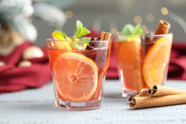 Beyaz ahşap masadaki gözlüklü ve baharatlı kokteyller arka planda bulanık ışıklarla, yakın plan. Bokeh etkisi