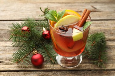 Bardakta kokteyl, baharat ve Noel süsü, ahşap masada, yakın plan.