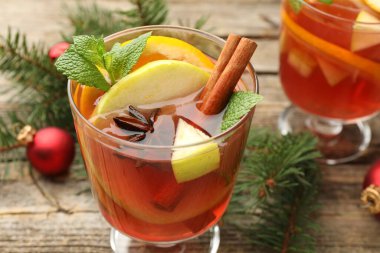 Lezzetli punç bardaklar, baharatlar ve Noel dekorları ahşap masada, yakın plan.