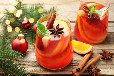 Bardaklarda, baharatlarda ve Noel dekorunda nefis kokteyller, ahşap masada, yakın plan. Bokeh etkisi