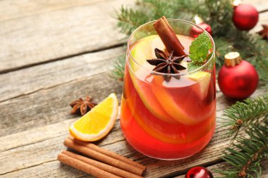 Bardakta kokteyl, baharat ve Noel süsü, ahşap masada, yakın plan. Metin için boşluk