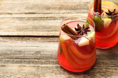 Lezzetli punç içeceği ve bardaktaki baharatlar ahşap masada, yakın plan. Metin için boşluk