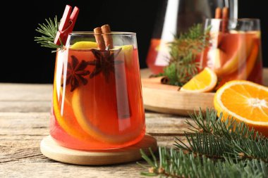 Bardakta, sürahide, portakalda ve Noel dekorunda nefis punç içeceği, ahşap masada, yakın plan.