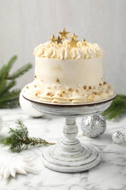 Beyaz mermer masanın üzerinde Noel dekoru olan nefis bir pasta, yakın plan.