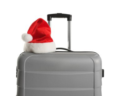 Beyaz üzerinde Noel Baba şapkası olan şık gri bavul. Noel tatili