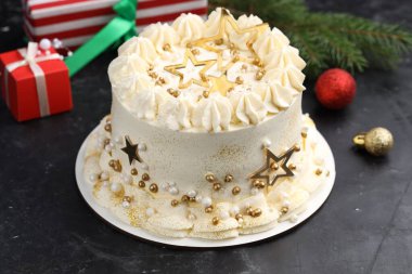 Siyah masanın üstünde Noel süsü olan nefis bir pasta, yakın plan.