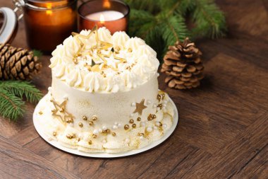 Noel dekorlu lezzetli pasta ve ahşap masada yanan mumlar, yakın plan. Metin için boşluk