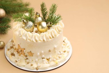 Bej arka planda Noel dekoru olan lezzetli bir pasta, yakın plan. Metin için boşluk