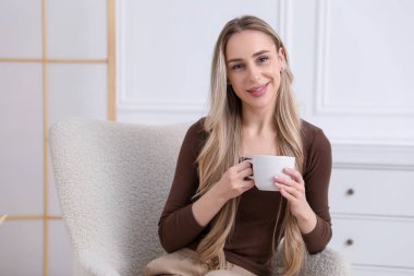 Evdeki koltukta nefis kakao içen bir kadın. Metin için boşluk