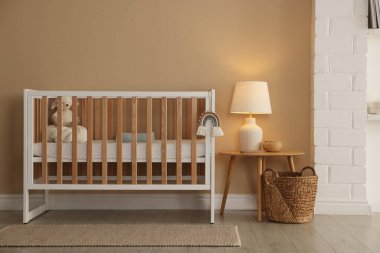 Beşik, masa ve dekorlu şık bir bebek odası. İç tasarım