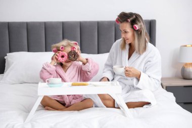 Anne ve kızı evde çay partisi veriyor.