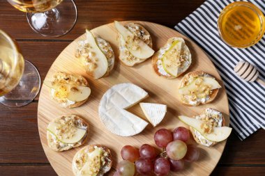 Peynirli bruschettalar, üzümler ve şarapla servis edilen ahşap masa, düzlük.