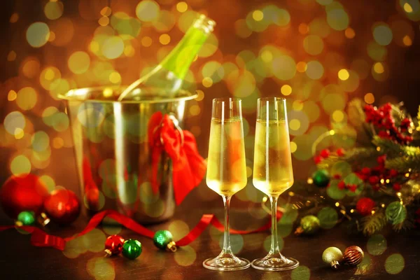 Bardakta köpüklü şarap, şenlikli dekor, ışık. Yeni yıl tebrik kartı.