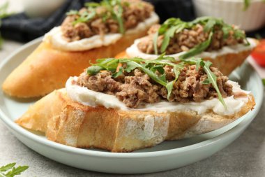 Gri masada ton balığı, krem peynir ve roka ile nefis bruschettalar.