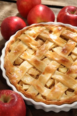 Ev yapımı elmalı turta ve elmalar ahşap masada, yakın plan.