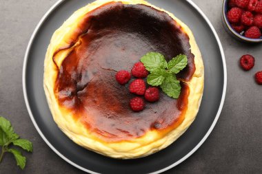 Lezzetli Bask peynirli keki, ahududu ve nane şekeri gri desenli masa, düz uzanma