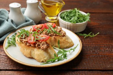 Lezzetli bruschettalar, ton balığı, domates ve roka, ahşap masa, yakın plan.