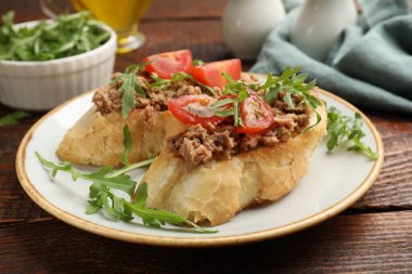 Lezzetli bruschettalar, ton balığı, domates ve roka, ahşap masa, yakın plan.