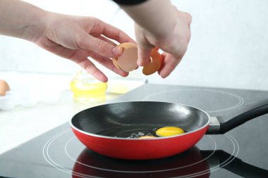 Mutfakta yumurta kıran bir kadın, yakın plan.