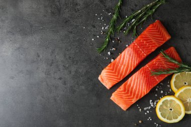 Somon fileto ve baharat parçaları gri masada, düz yerde. Metin için boşluk
