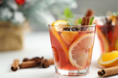 Bardakta kokteyl, baharat ve Noel süsü, beyaz masada, yakın plan. Metin için boşluk