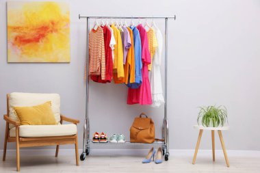 Rafta, sırt çantasında, ayakkabılarda ve koltukta asılı farklı şık kıyafetler.