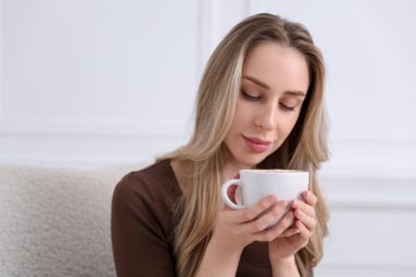 Güzel bir kadın evde kakao aromalı içkinin tadını çıkarıyor. Metin için boşluk