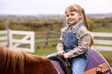 At destekli terapi. Küçük kız dışarıda güzel bir midilliye biniyor. Sevimli evcil hayvan