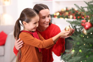 Anne ve kızı evde Noel ağacı süslüyorlar.