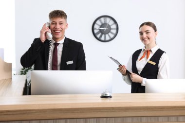 Otel resepsiyonunda çalışan resepsiyonist ve hostes