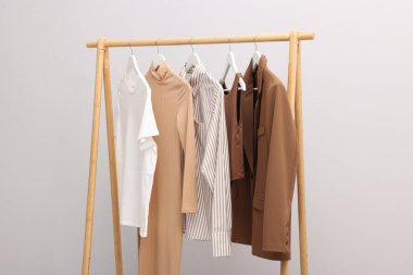 İçerideki duvarın yanındaki askıda asılı farklı şık kıyafetler.