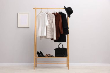 İçerideki duvarın yanında farklı şık kıyafetler, aksesuarlar ve ayakkabılar.