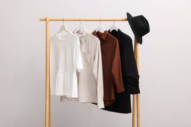 İçerideki duvarın yanındaki askıda asılı farklı şık kıyafetler.