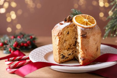 Noel yemeği. Lezzetli Panettone pastası ve bej masa üzerindeki şenlikli dekor, yakın plan.