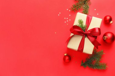 Firavun ağacı dalları, hediye ve kırmızı arka planda Noel süsü, düz bir zemin. Metin için boşluk