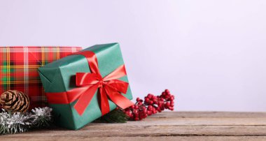 Firavun ağacı dalları, hediye kutuları ve ahşap masanın üzerindeki diğer Noel dekorları açık gri arka plan, yakın plan. Metin için boşluk