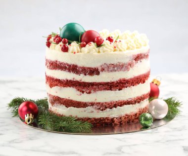 Noel dekorlu lezzetli sünger keki ve beyaz mermer masa üzerindeki kırmızı üzümlü üzümlü krema gri arka planda, yakın plan