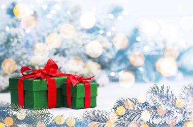 Hediye kutuları ve bokeh ışıkları olan Noel tebrik kartı.