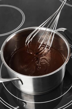 Erimiş çikolatayla çırpıcıyı karıştırıyorum, yakın plan.