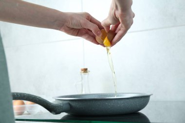 Mutfakta yumurta kıran bir kadın, yakın plan.