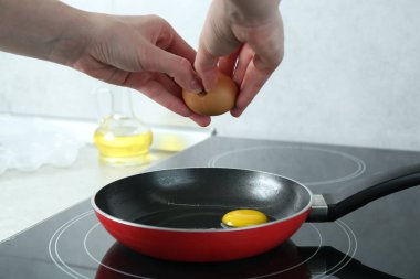 Mutfakta yumurta kıran bir kadın, yakın plan.