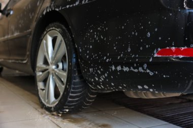 Oto yıkamada temizlik köpüğüyle kaplanmış, yakın plan.